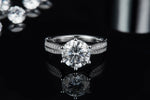 CARISSIE round moissanite solitaire ring, front view on reflective background emphasizing symmetry and sparkle