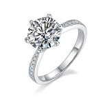CARISSIE round moissanite solitaire ring, angled view highlighting the brilliant center stone and pavé split shank band.