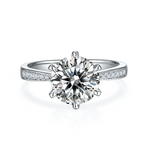 CARISSIE round moissanite solitaire ring, top-down view showcasing the six-prong setting and pave accents on both shoulders.