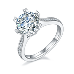 CARISSIE round moissanite solitaire ring, angled view highlighting heart-shaped prongs and pavé split shank band