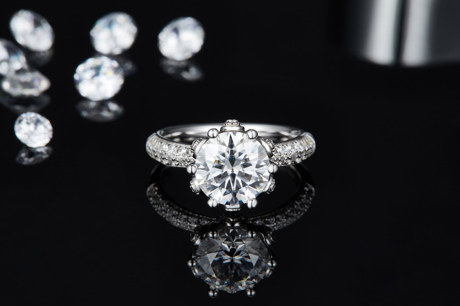 CARISSIE round moissanite engagement ring, top-down perspective on glossy black background showing clear reflection