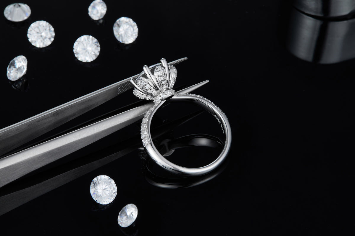 CARISSIE round moissanite engagement ring, held by tweezers to reveal detailed craftsmanship of the pavé gallery