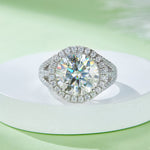 CARISSIE round moissanite halo engagement ring, displayed on a white pedestal to emphasize the sparkle of the silver-tone setting
