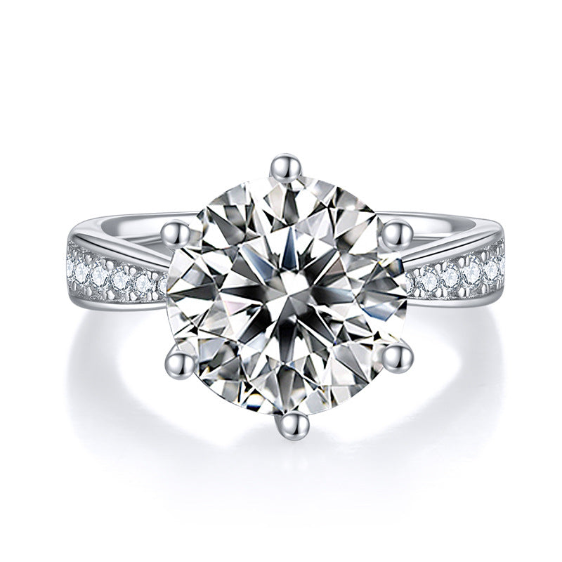 CARISSIE round moissanite solitaire ring, front view highlighting six-prong setting and pave accents on silver-tone metal