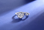 CARISSIE round moissanite bezel ring, side profile on blue background displaying asymmetrical open band shape