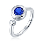 CARISSIE round moissanite bezel ring, close-up product view of blue stone highlighting smooth rounded setting