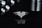 CARISSIE heart-shaped moissanite ring, front view on reflective dark surface displaying brilliant sparkle