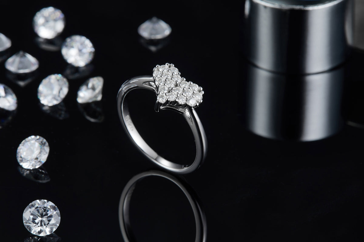 CARISSIE moissanite jewelry piece, lifestyle shot on black surface with loose stones in background