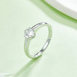 CARISSIE oval moissanite bezel ring, side angle on green background displaying the interior metal stamping