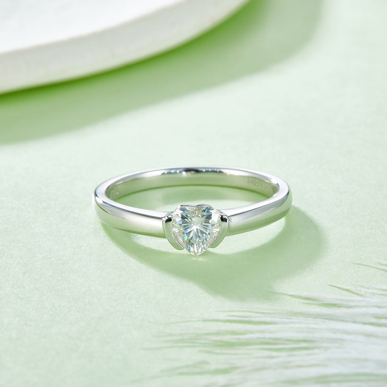 CARISSIE heart moissanite bezel ring, top-down angle emphasizing the symmetry of the heart shape in white metal.