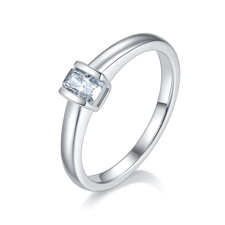 CARISSIE emerald cut bezel engagement ring, angled view showing the sleek silver band and rectangular moissanite stone
