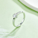 CARISSIE pear moissanite bezel engagement ring, diagonal angle showing the seamless flow from the band to the stone setting