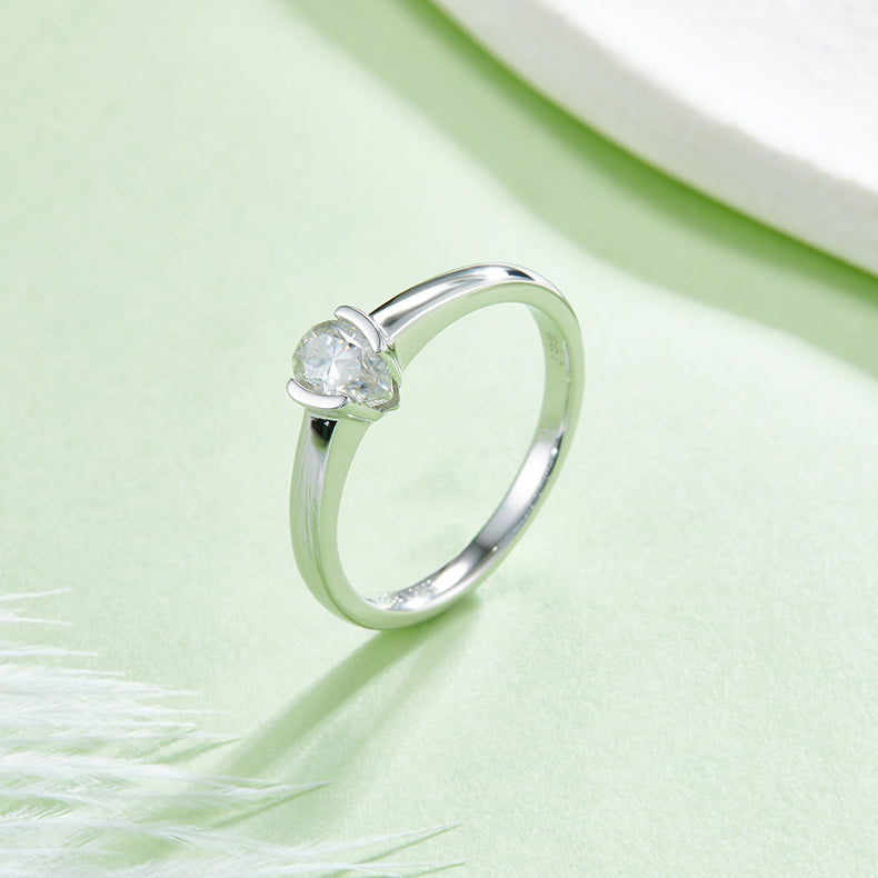 CARISSIE pear moissanite bezel engagement ring, diagonal angle showing the seamless flow from the band to the stone setting