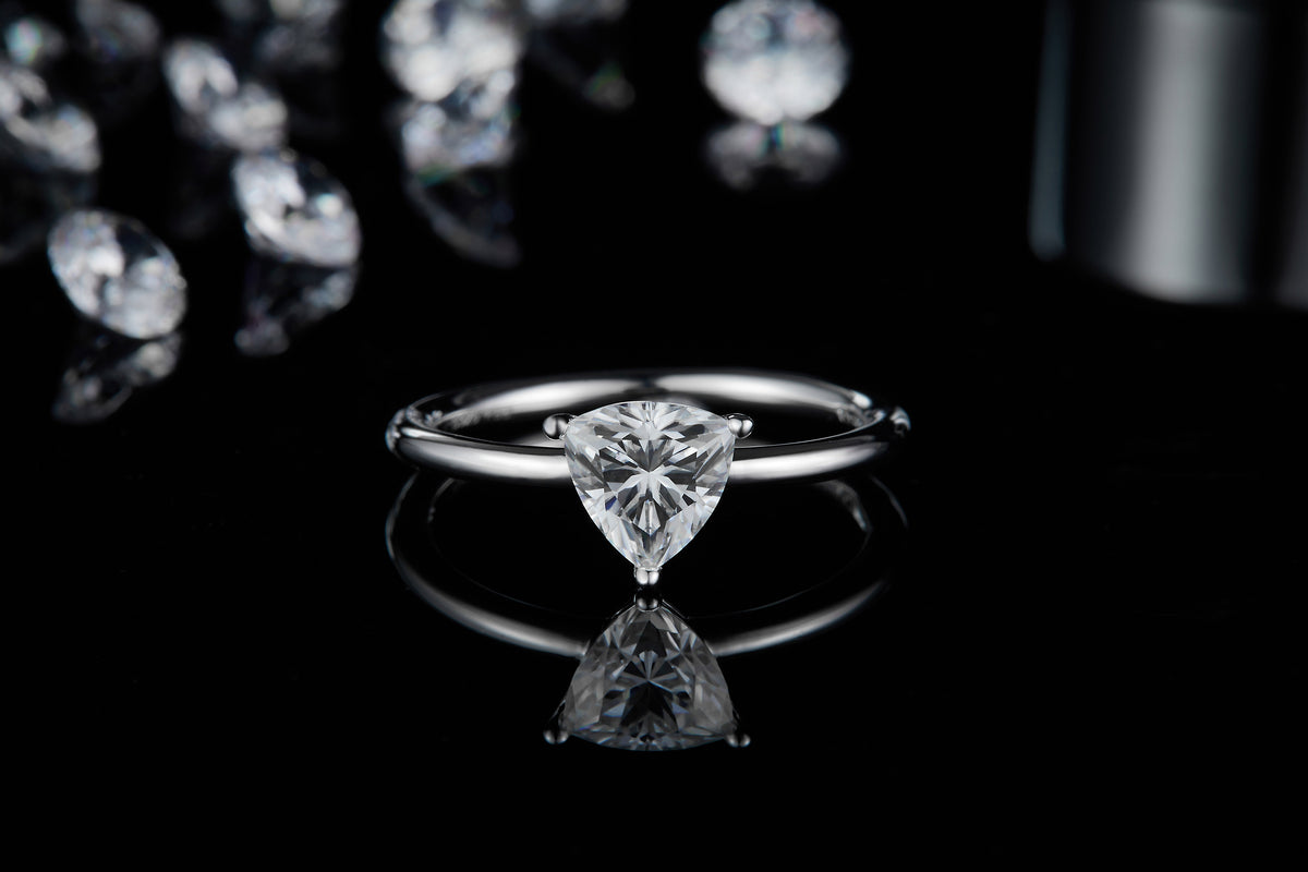 CARISSIE trillion engagement ring, straight-on view displaying the brilliant sparkle of the center stone against a dark backdrop