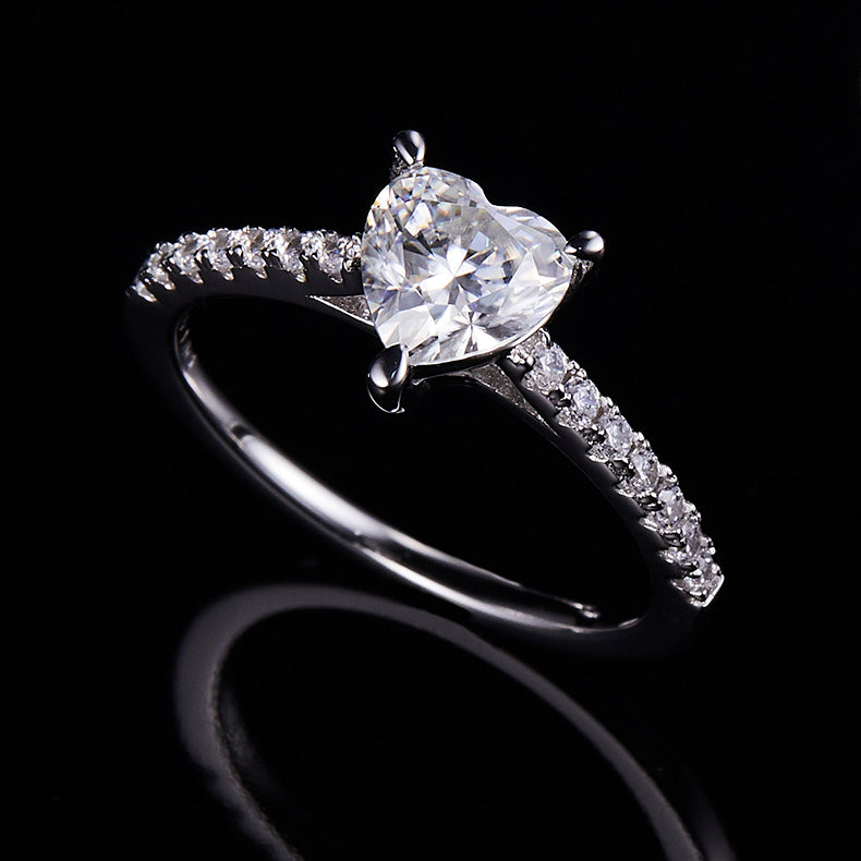 CARISSIE heart solitaire engagement ring, dramatic dark background shot emphasizing the brilliance of the moissanite and silver metal