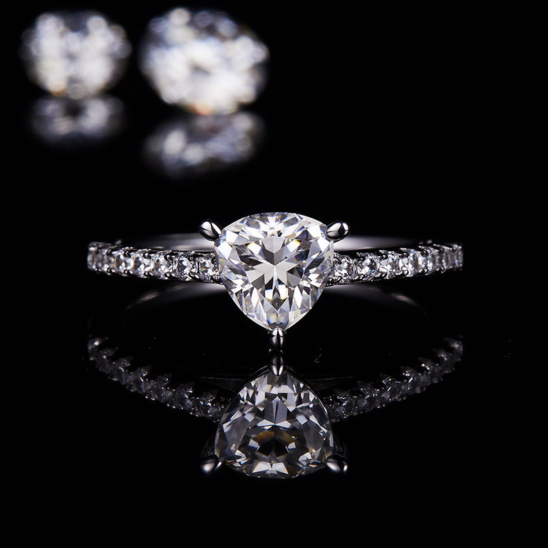 CARISSIE trillion solitaire engagement ring, straight-on view with reflection on dark surface showcasing the clarity of the gemstone