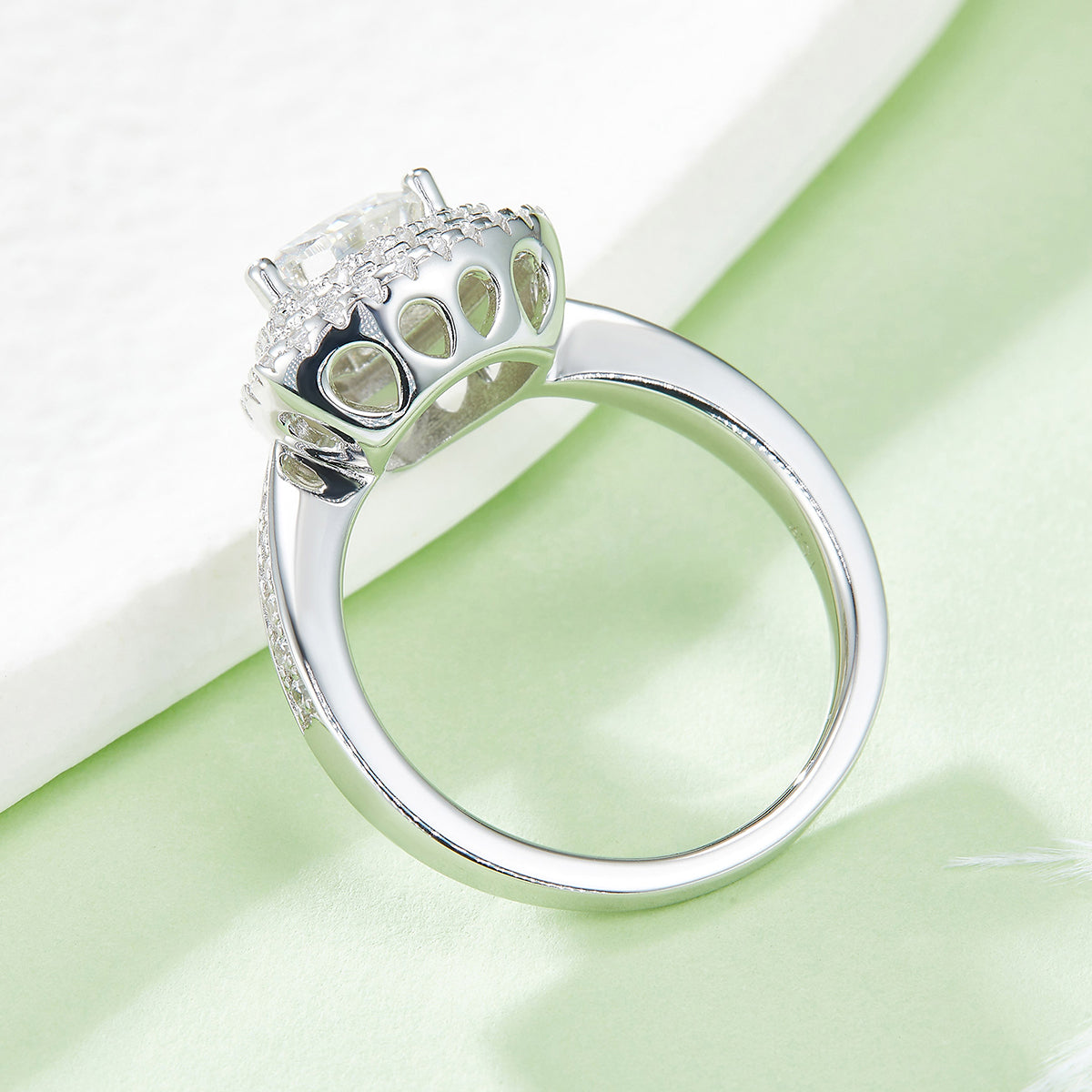 CARISSIE trillion halo engagement ring, low-angle view showing the airy under-gallery structure and polished white metal finish