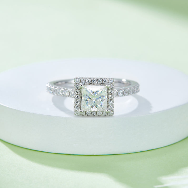 CARISSIE princess halo engagement ring, centered view on a white pedestal displaying the full sparkle of the square moissanite
