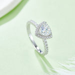 CARISSIE trillion halo engagement ring, angled view on green background showing split shank and pavé band details