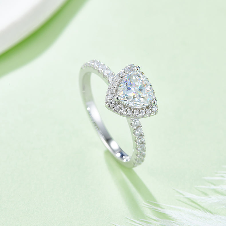CARISSIE trillion halo engagement ring, angled view on green background showing split shank and pavé band details