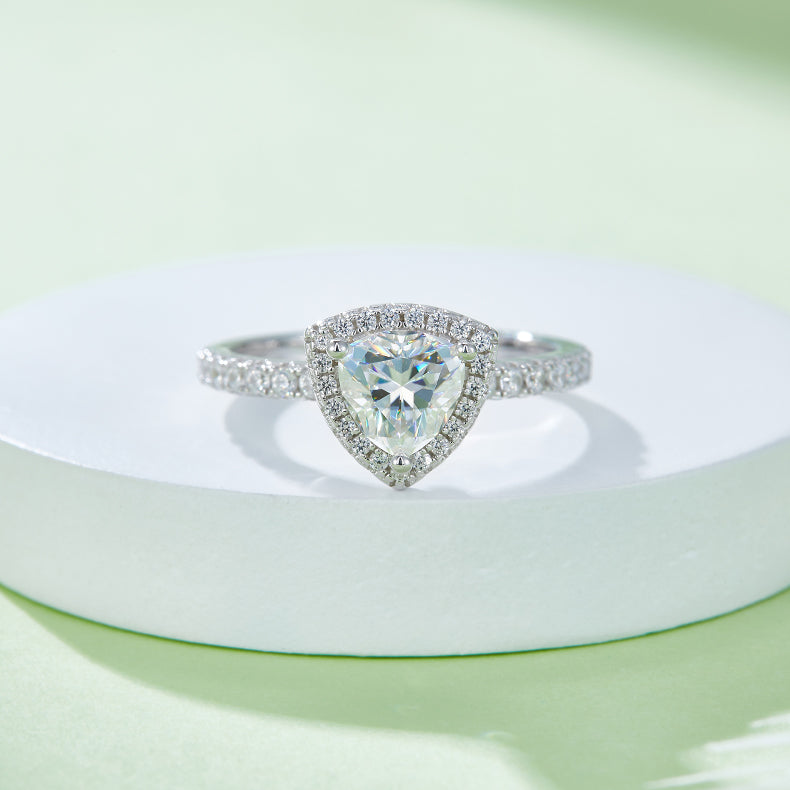 CARISSIE trillion halo engagement ring, front view on white pedestal highlighting the triangular center stone and halo