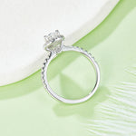 CARISSIE pear moissanite halo engagement ring, under-view on green surface showing interior metalwork