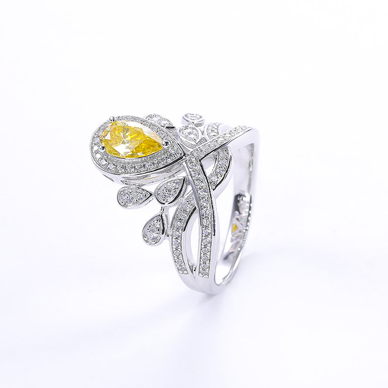 CARISSIE pear moissanite halo ring, product photography of the yellow stone edition featuring delicate leaf accents
