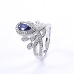 CARISSIE pear moissanite halo ring, isolated studio shot of the blue stone version against a clean white background