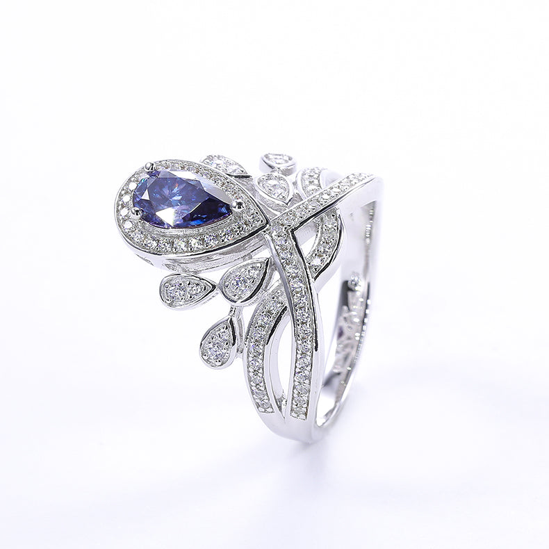 CARISSIE pear moissanite halo ring, isolated studio shot of the blue stone version against a clean white background