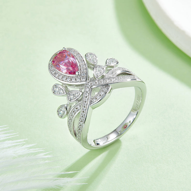 CARISSIE pear moissanite halo ring, side angle of the pink stone option emphasizing the intricate crossover band