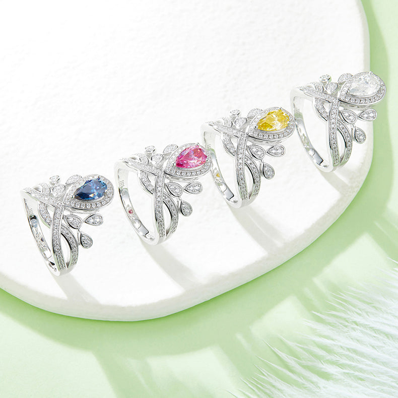 CARISSIE pear moissanite halo ring set, lineup of four color variations displayed on a textured white surface
