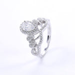 CARISSIE pear moissanite halo engagement ring, oblique view emphasizing the classic white color option and sculptural twisted band shape