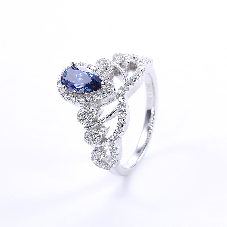 CARISSIE pear moissanite halo engagement ring, three-quarter angle showcasing a deep blue center gemstone set in silver-tone metal