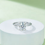 CARISSIE oval moissanite solitaire ring, centered on a white pedestal showing the symmetrical placement of the oval stone