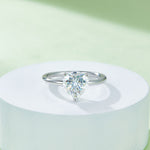 CARISSIE heart moissanite solitaire ring, elevated display on a white pedestal emphasizing the minimalist design