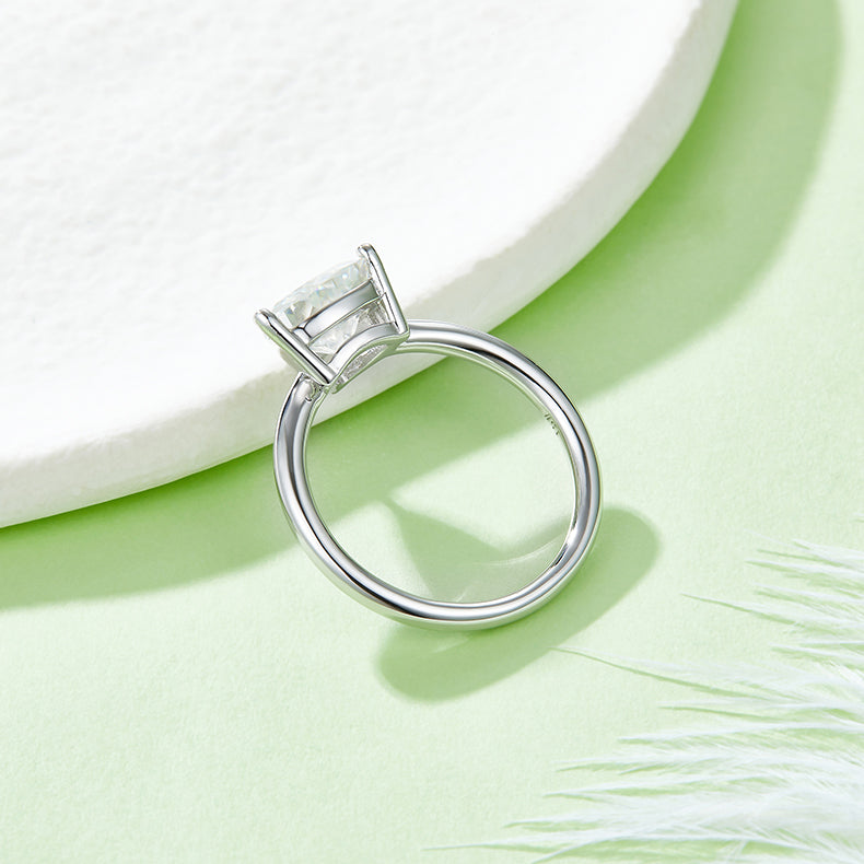 CARISSIE trillion solitaire engagement ring, top-down angle showing the secure three-prong basket and circular band structure