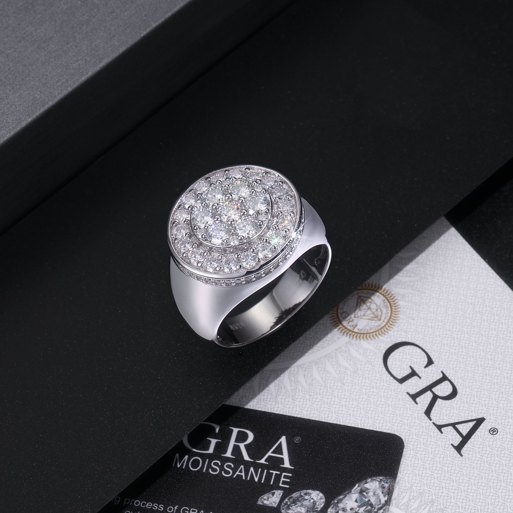 CARISSIE cushion cut moissanite ring resting in a black jewelry box next to a GRA certificate card and warranty information