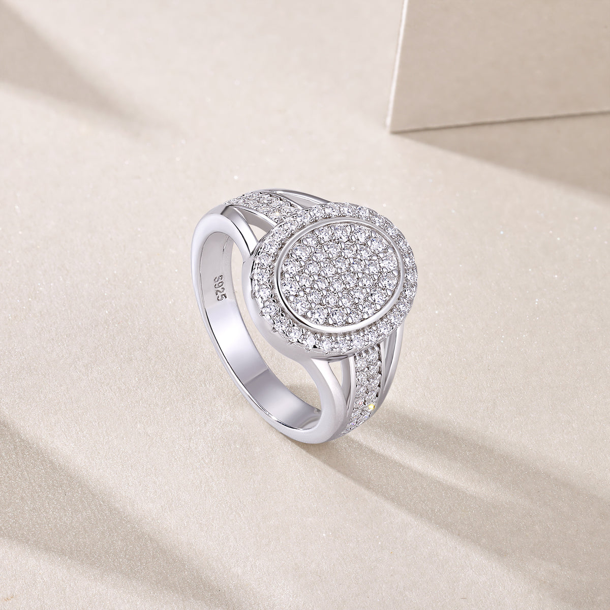 CARISSIE round moissanite halo ring, lifestyle angle on beige surface highlighting S925 stamp inside the band