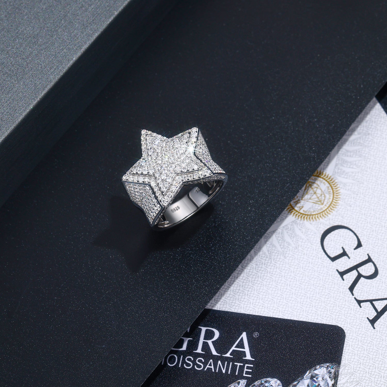 CARISSIE round moissanite pavé ring, top-down view of star motif on black box with GRA certificate