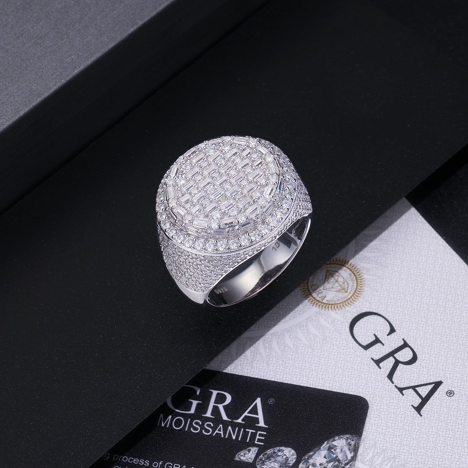 CARISSIE round moissanite statement ring, lifestyle shot resting on a black box next to a GRA certificate card