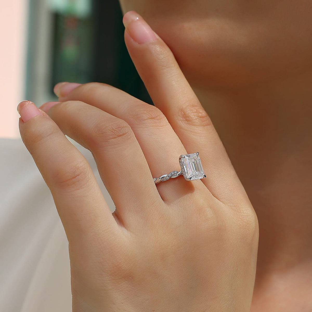 Emerald-cut moissanite solitaire engagement ring worn on the hand