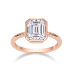 Thea Emerald Cut Moissanite Bezel Engagement Ring in 18K rose gold plating, front view