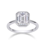 Thea Emerald Cut Moissanite Bezel Engagement Ring in 18K white gold plating, front view